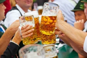 Brinde coletivo com canecos de chope durante celebração de festa típica alemã