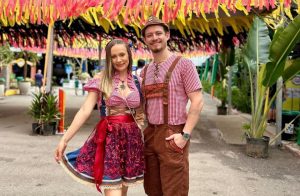 Casal com trajes típicos alemães em ambiente decorado para a Schützenfest, em Jaraguá do Sul
