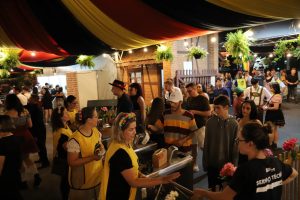 Fila de visitantes na entrada da Schützenfest com decoração típica alemã