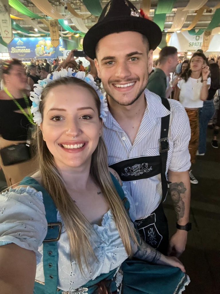 Casal posa sorridente à noite com trajes típicos na Schützenfest