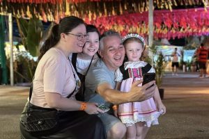 Família faz selfie com criança vestida de traje típico na Schützenfest em Jaraguá do Sul
